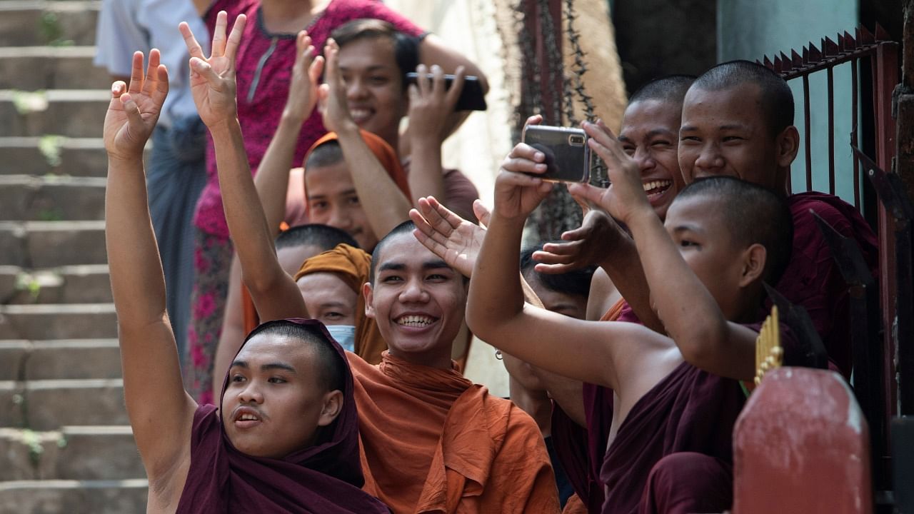 Buddhist monks show the three-finger salute as they take part in a protest against the military coup and to demand the release of elected leader Aung San Suu Kyi, in Yangon, Myanmar. Credit: AFP Photo.