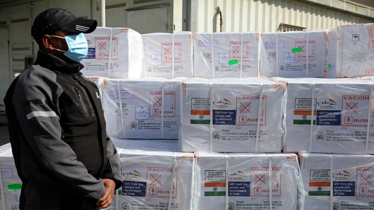  An Indian security guard stands next to the first shipment of 500,000 doses of the AstraZeneca coronavirus vaccine made by Serum Institute of India, donated by the Indian government to Afghanistan, in Kabul, Afghanistan. Credit: AP/PTI Photo. 