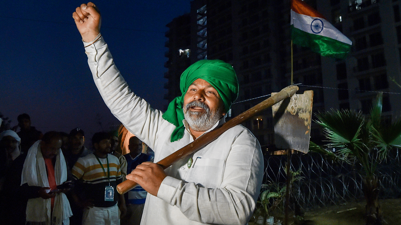 BKU leader Rakesh Tikait holding a spade raises slogans during farmers' ongoing protest against Centre's new farm laws, at Ghazipur border in New Delhi. Credit: PTI Photo