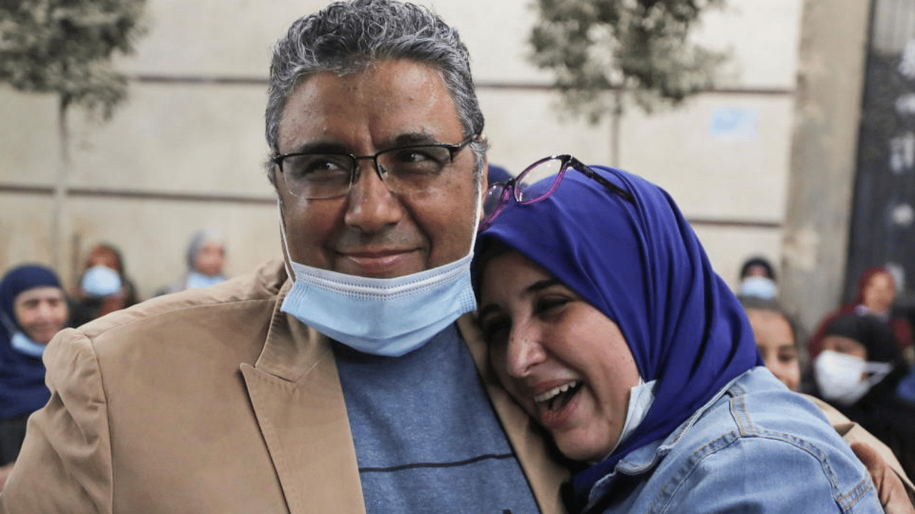 Journalist Mahmoud Hussein embraces with his daughter after being released by Egyptian authorities after four years in detention on accusations of publishing false news, in Abou Al Nomros, in Giza, Egypt February 6, 2021. Credit: Reuters  Photo