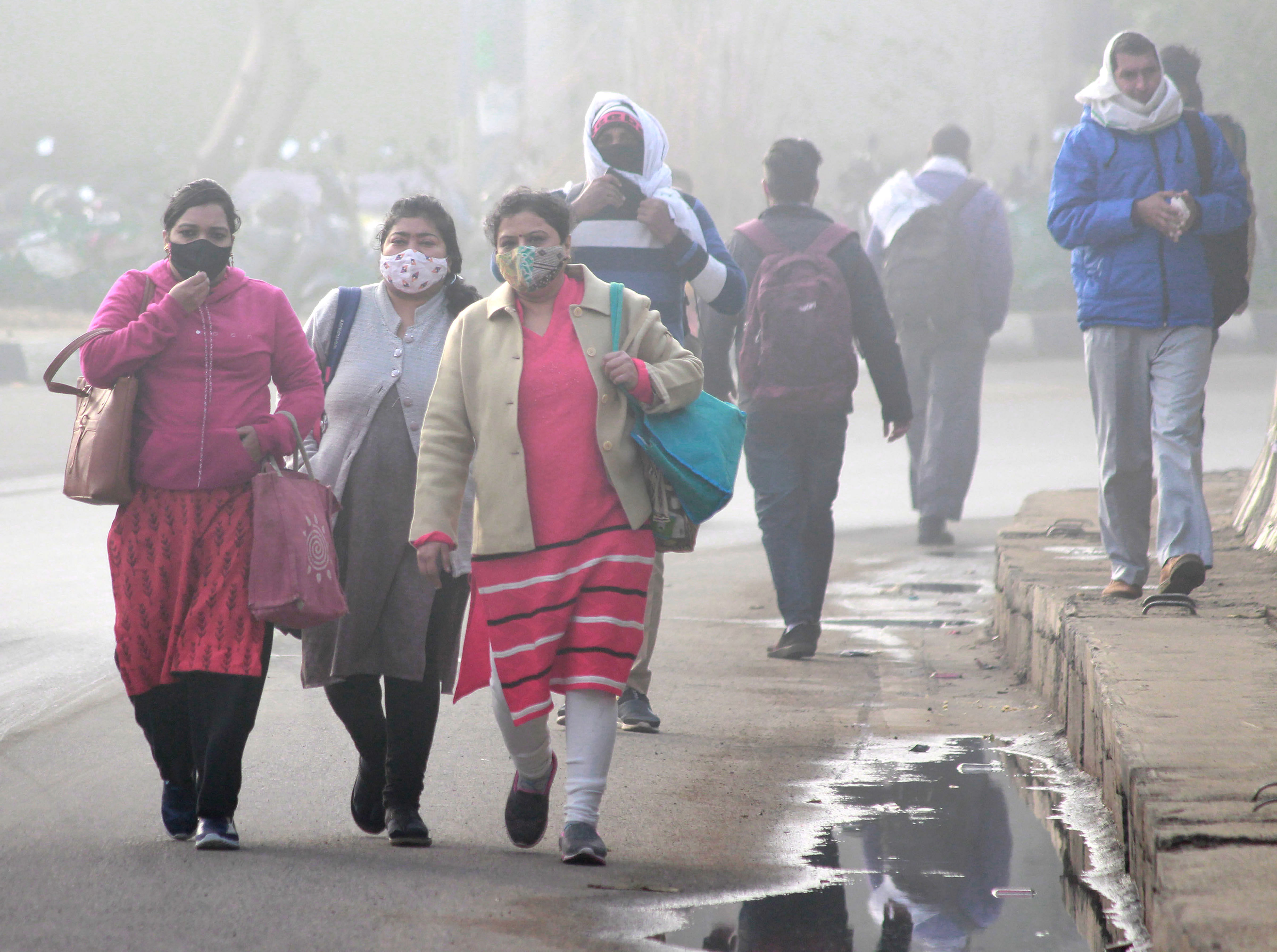 Commuters walk on a road amid low visibility due to fog, on a cold winter morning in Gurugram, Friday, Feb. 5, 2021. Credit: PTI Photo