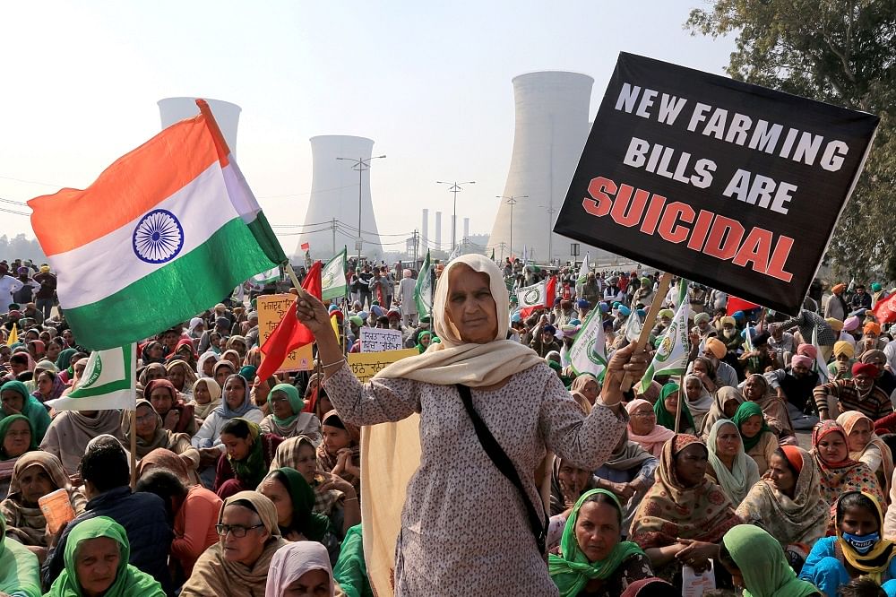 Farmers block a road during their 'chakka jam' protest as part of the ongoing agitation over new farm laws. Credit: PTI Photo