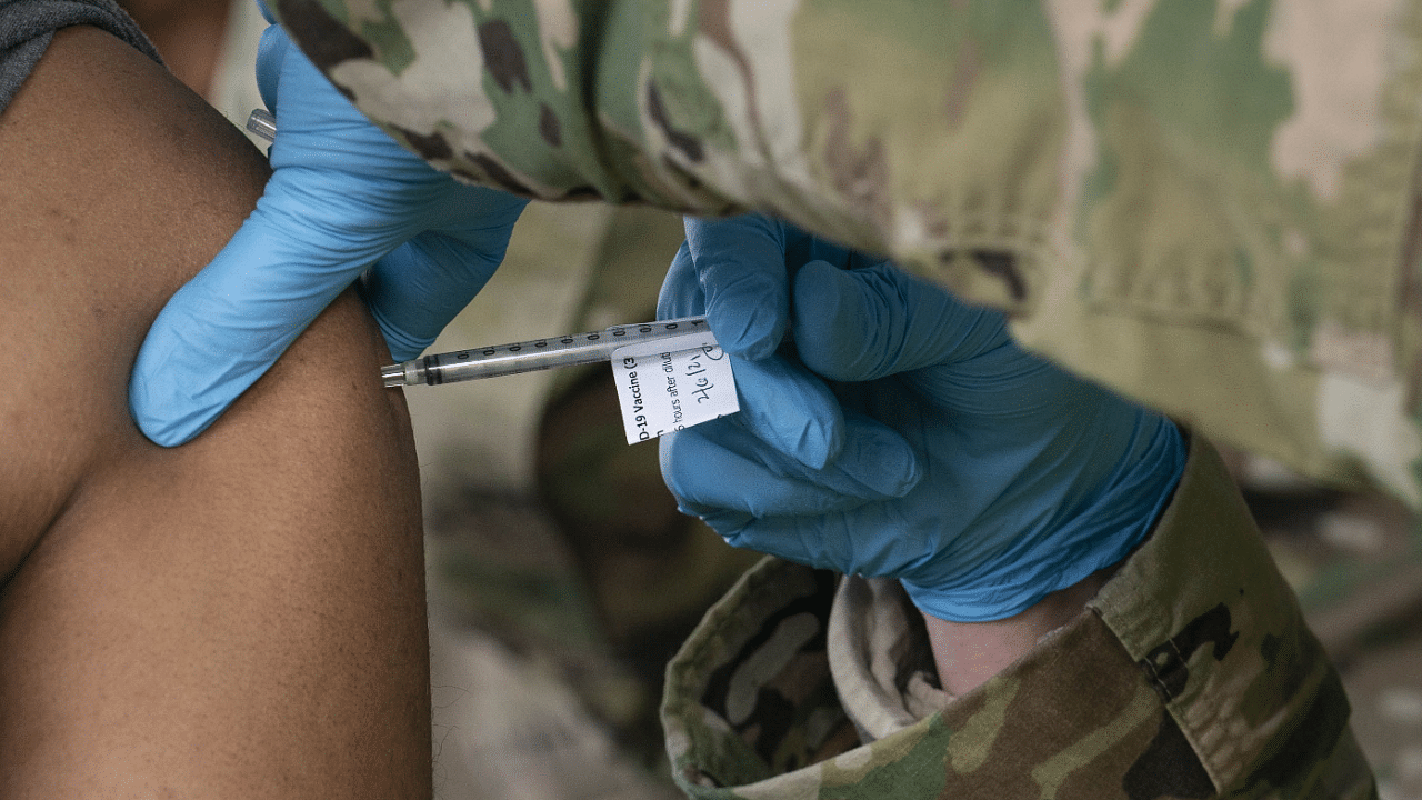A man receives a coronavirus vaccine from a member of the National Guard. Credit: AFP Photo