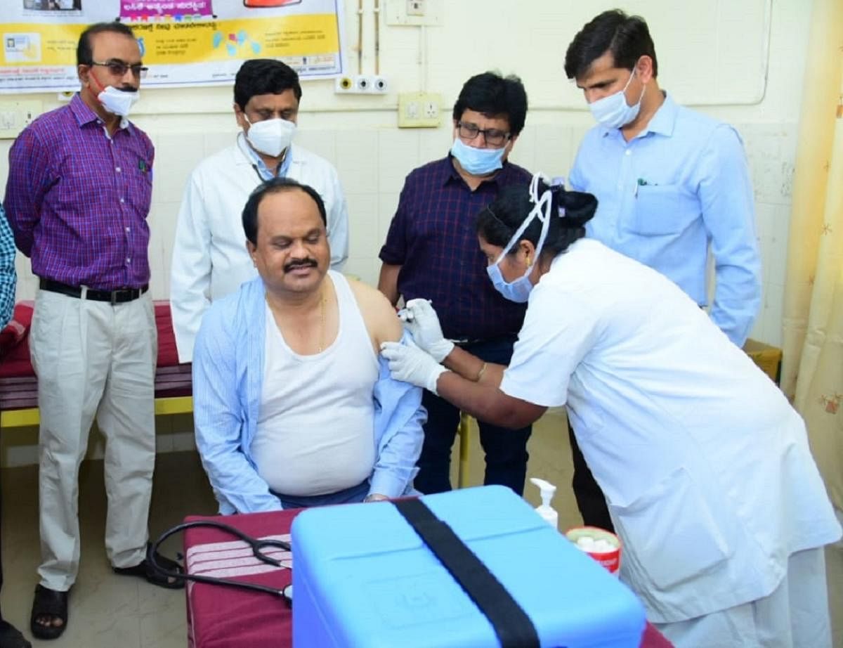 Deputy Commissioner M R Ravi gets his Covid-19 vaccine at the district hospital in Chamarajanagar on Monday. Credit: DH Photo