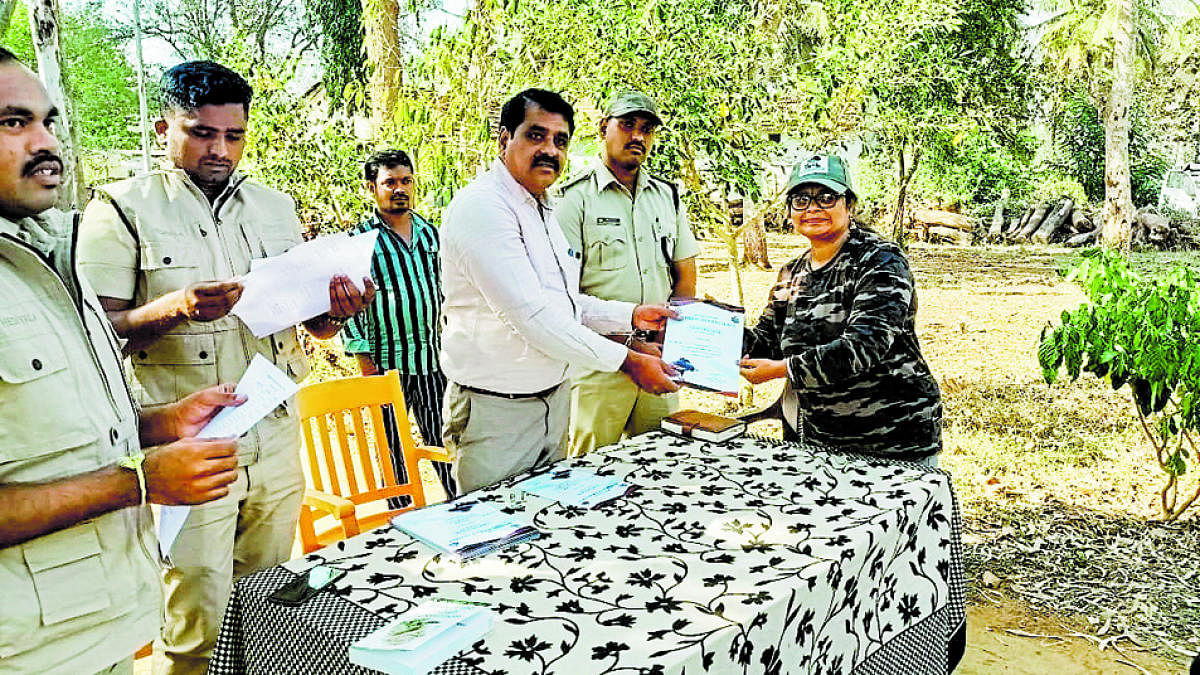 Assistant Conservator of Forest Ravi Kumar distributes certificate to a volunteer, who participated in the bird census at Bandipur forest, recently.