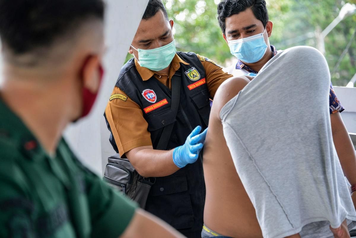 Medical workers treat a Christian man's wounds on his back after being flogged by a member of the Sharia police for being caught gambling in Banda Aceh. Credit: AFP photo. 