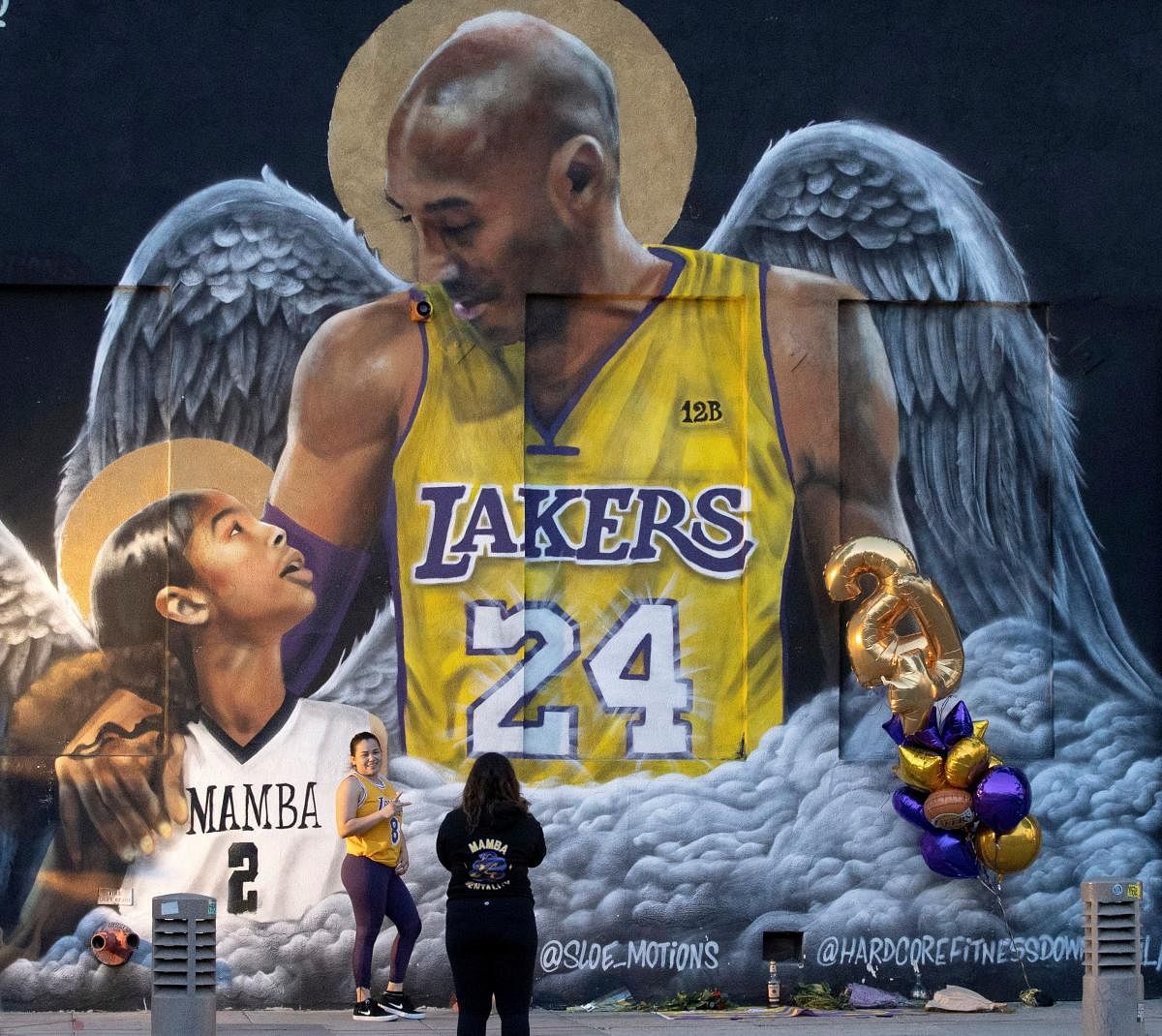 A fan poses by a mural of late Kobe Bryant, who perished one year ago alongside his daughter and seven others when their helicopter crashed into a hillside, in Los Angeles, California, U.S., January 26, 2021. Credit: REUTERS Photo