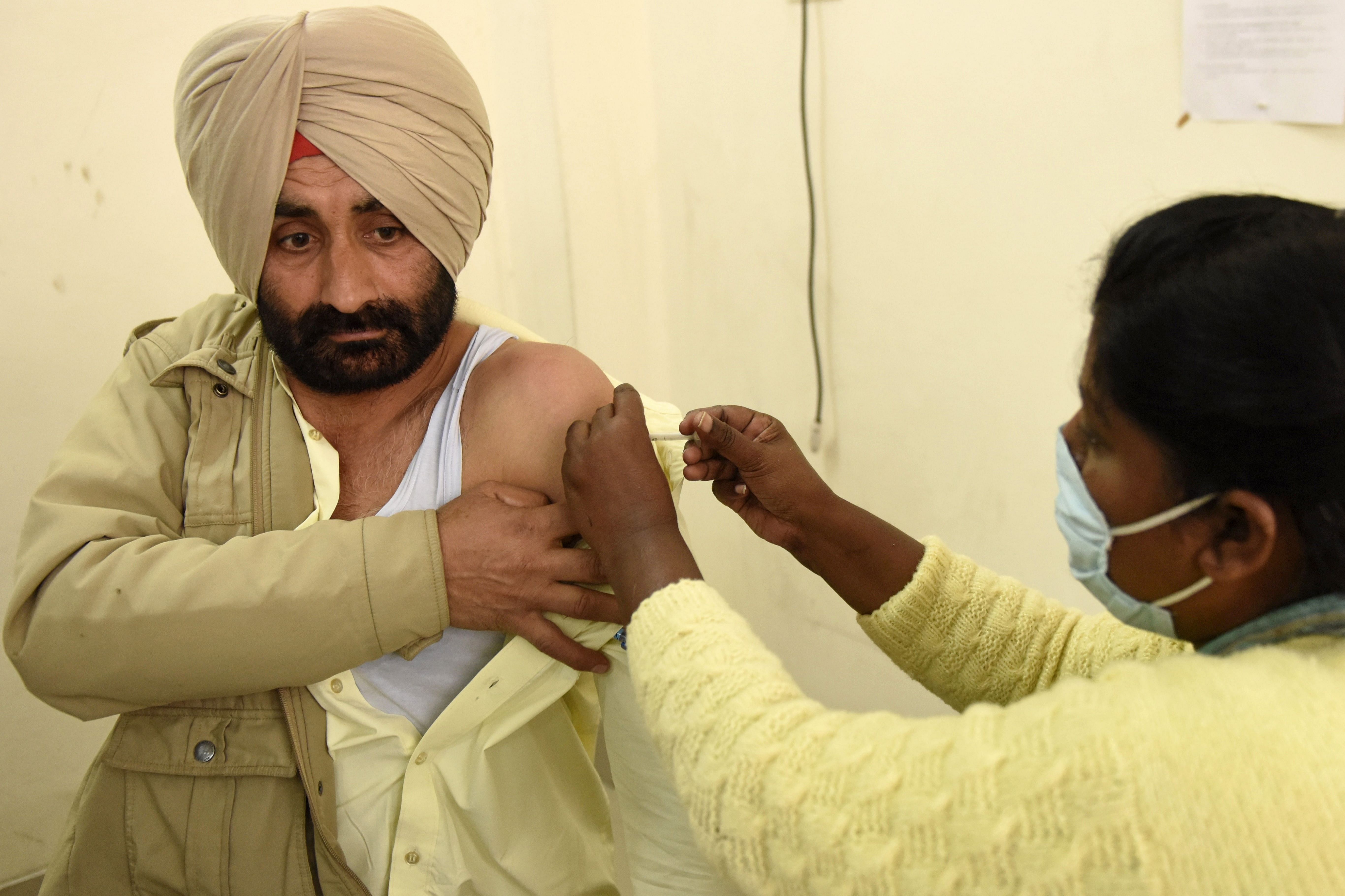 A medical staff inoculates a police personnel with a Covid-19 coronavirus vaccine at the Civil hospital. Credit: AFP Photo