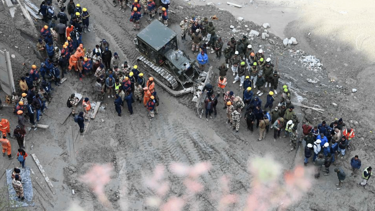 Rescue teams gather near the entrance of a tunnel blocked with mud and debris, where workers are trapped, in Tapovan of Chamoli district on February 9, 2021 following a flash flood thought to have been caused when a glacier burst on February 7.  Credit: AFP Photo