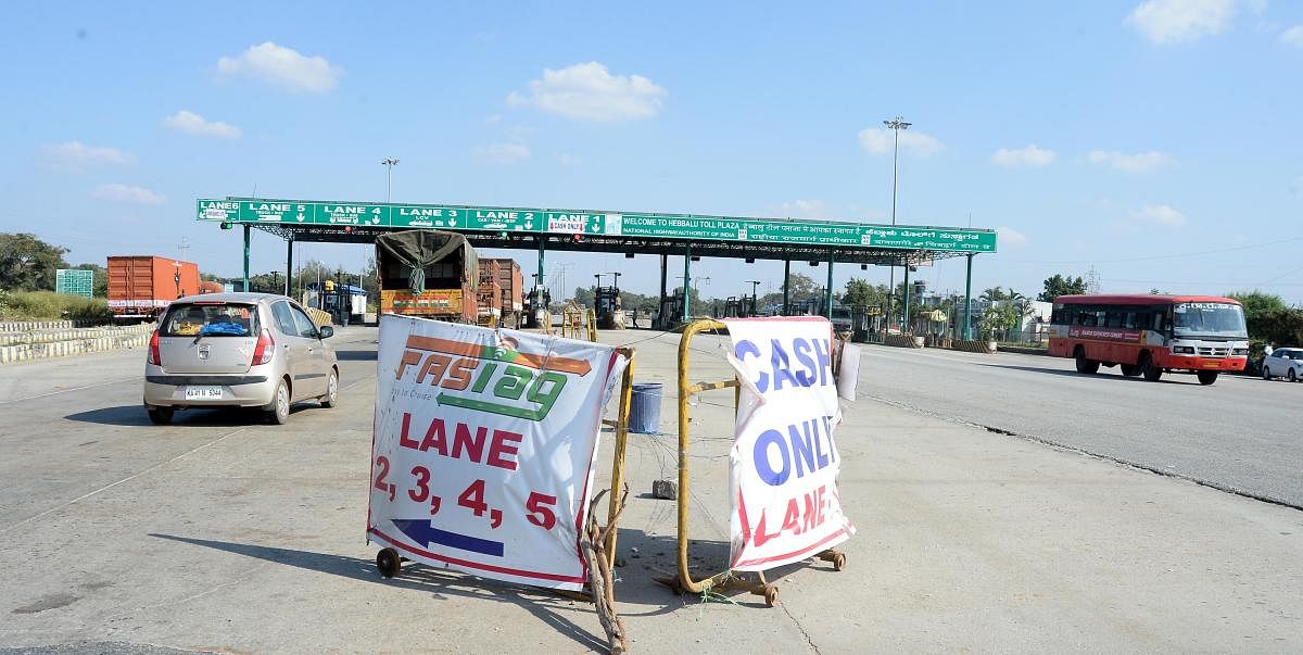 The peak hours see long lines of vehicles waiting at the toll plaza where a collection of the toll by cash is leading to delays. Credit: DH Photo