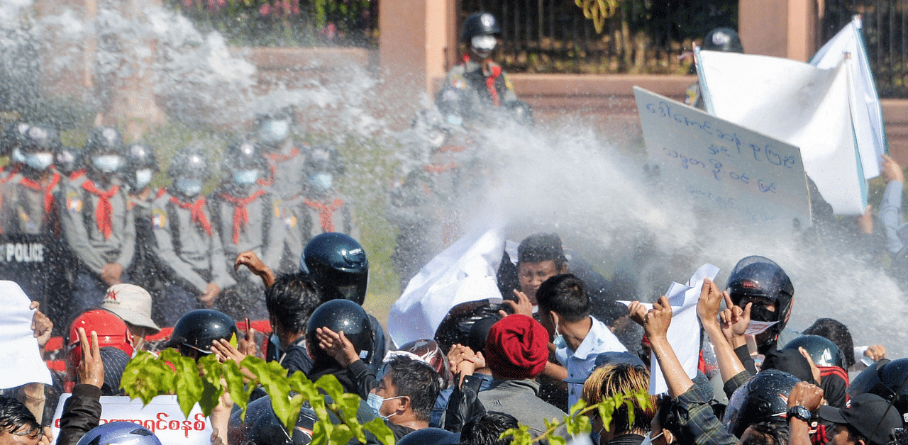 Myanmar police (in background) fire water cannon at protesters as they continue to demonstrate against the February 1 military coup in the capital Naypyidaw. Credit: AFP Photo