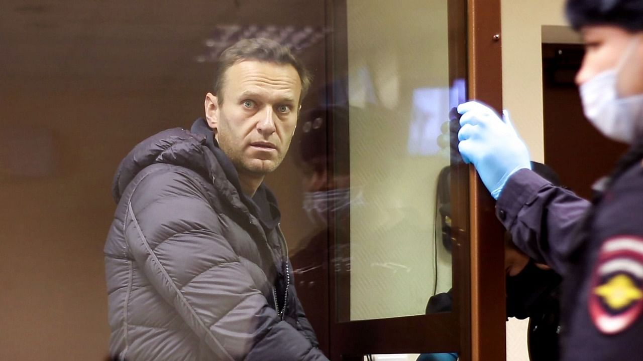 This screen grab from a handout footage provided by the Babushkinsky district court on February 5, 2021, shows Russian opposition leader Alexei Navalny, charged with defaming a World War II veteran, looking from inside a glass cell during a court hearing in Moscow. Credit: AFP Photo