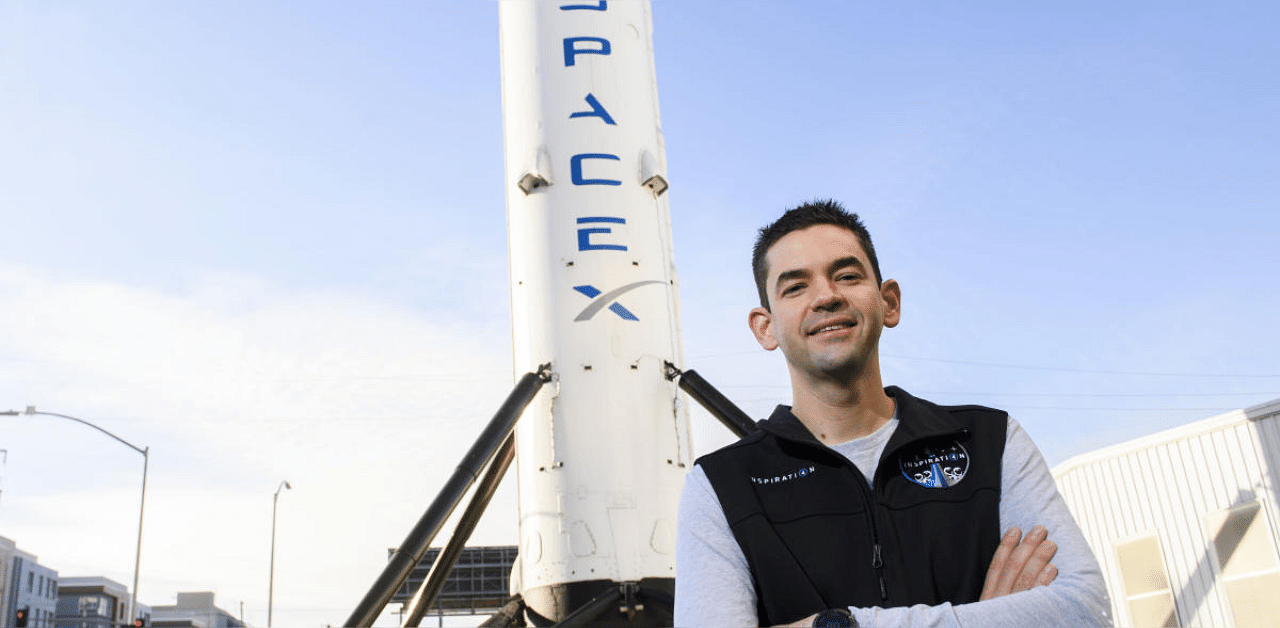 Inspiration4 mission commander Jared Isaacman, founder and chief executive officer of Shift4 Payments, stands for a portrait in front of the recovered first stage of a Falcon 9 rocket at Space Exploration Technologies Corp. (SpaceX). Credit: AFP photo. 