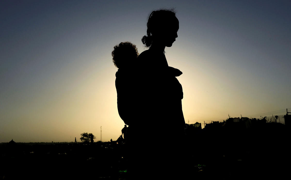 An Ethiopian woman who fled the ongoing fighting in Tigray region, carries her child near the Setit river on the Sudan-Ethiopia border in Hamdayet village in eastern Kassala state, Sudan November 22, 2020. Credit: REUTERS