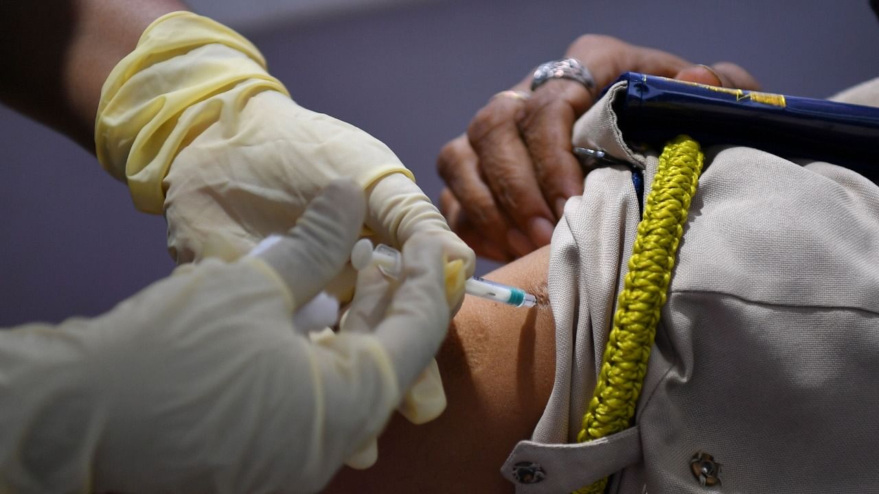 A medical staff inoculates a police personnel with a Covid-19 coronavirus vaccine at a vaccination centre in Mumbai on February 8, 2021. Credit: AFP Photo