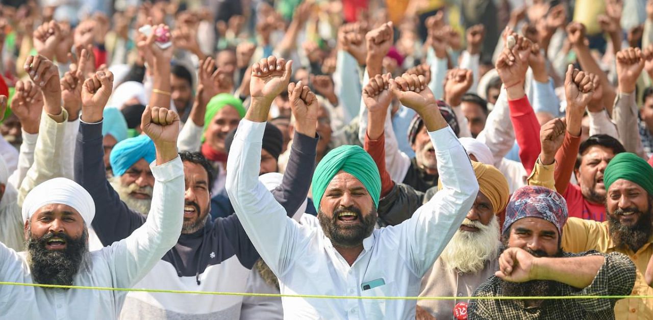 Farmers raise slogans during their protest against new farm laws, at Ghazipur border in New Delhi. Credit: PTI Photo. 
