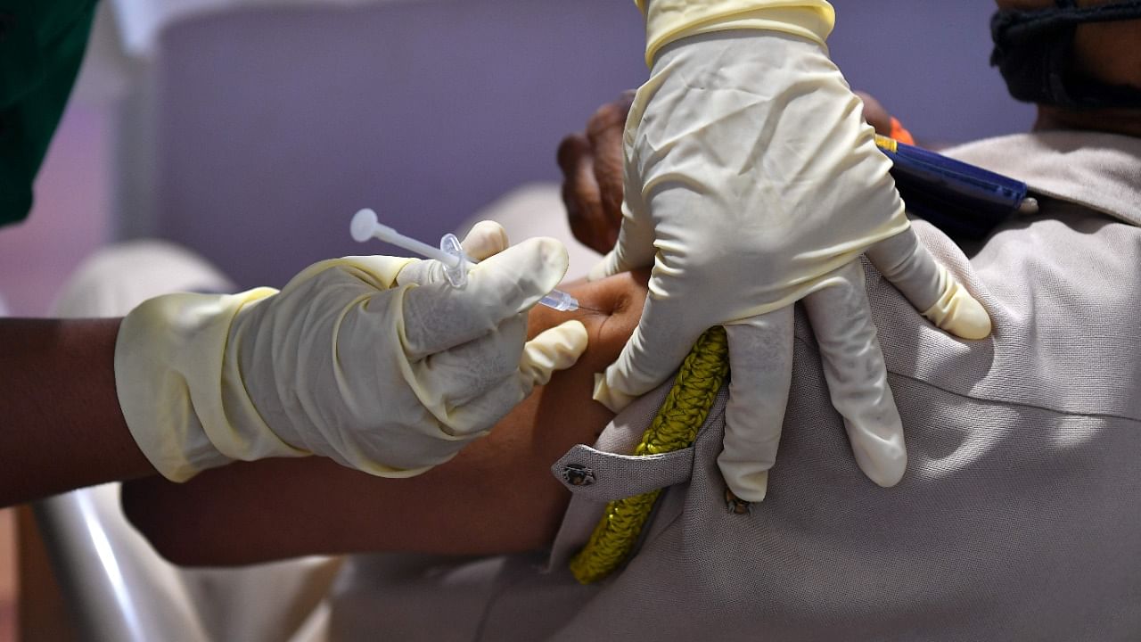 A medical staff inoculates a police personnel with a Covid-19 vaccine at a vaccination centre in Mumbai on February 8, 2021. Credit: AFP Photo