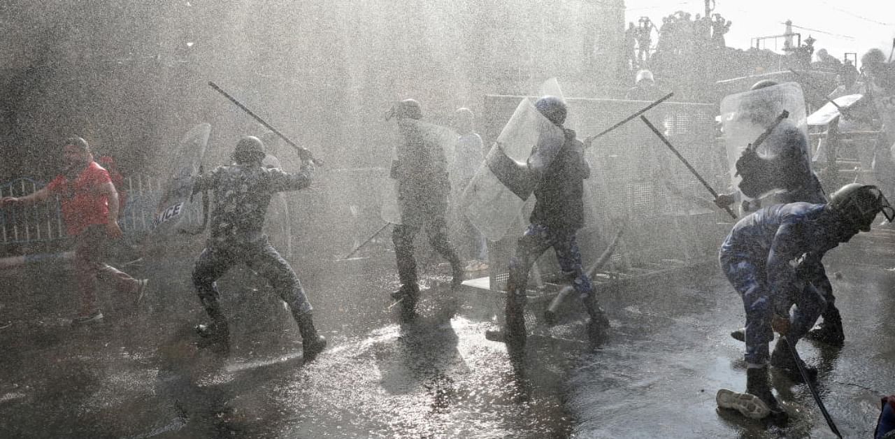 Police officers wield their batons against activists from various student unions amidst droplets by a police water cannon, during a protest march demanding jobs and better education facilities, in Kolkata, February 11, 2021. Credit: Reuters Photo