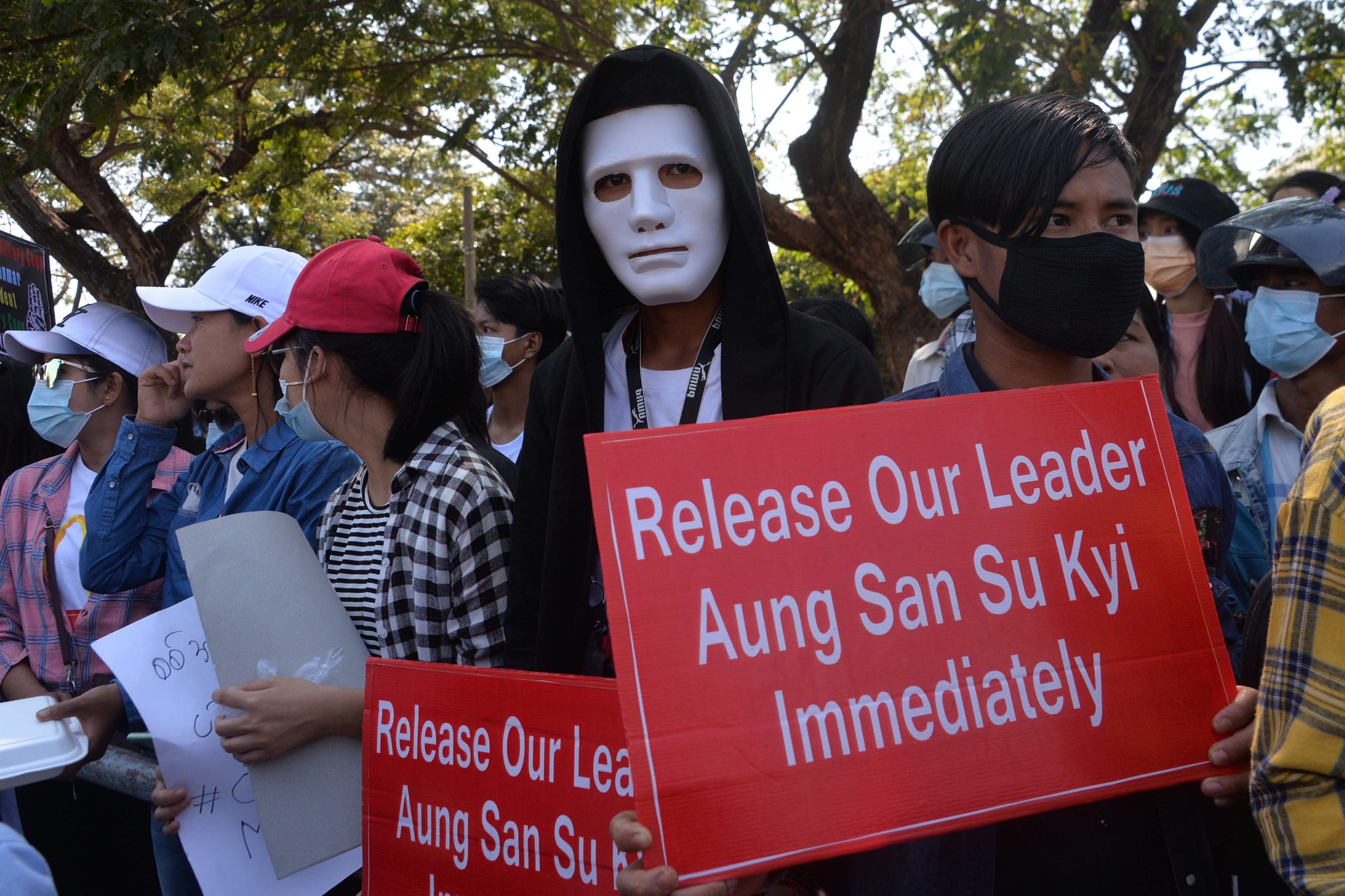 A protester wearing a mask holds up a sign during a demonstration against the military coup in Naypyidaw on February 13, 2021. Credit: AFP Photo