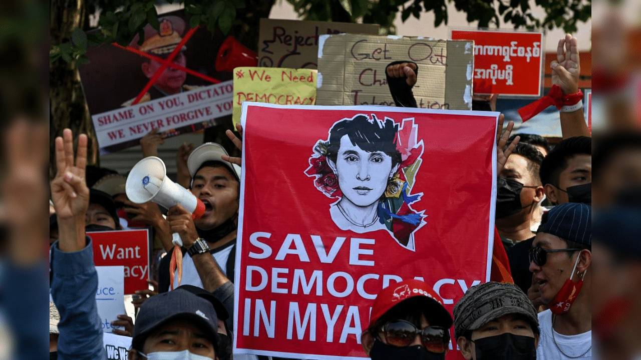 A sign with the image of detained Myanmar civilian leader Aung San Suu Kyi is carried at a demonstration against the military coup in front of the Chinese embassy in Yangon on February 12, 2021. Credit: AFP Photo