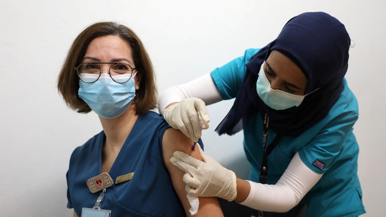 A healthcare worker receives a dose of the Pfizer/BioNTech vaccine against the coronavirus disease (COVID-19) during a coronavirus vaccination campaign at American University of Beirut's (AUB) medical centre in Lebanon. Credit: Reuters Photo.