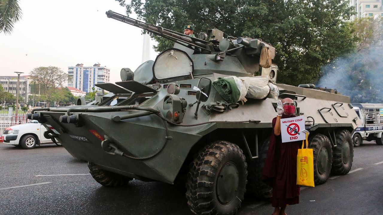 A Buddhist monk holding a sign stands next to an armoured vehicle during a protest against the military coup, in Yangon, Myanmar, February 14, 2021. Credit: Reuters Photo
