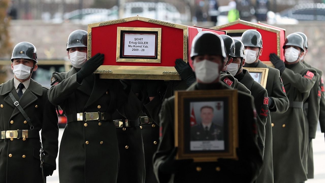 The coffin and image of Turkish Lt. Ertug Guler are carried during the funeral of three Turkish military personnel killed in action at Ankara's Ahmet Hamdi Akseki Mosque in Ankara . Credit: AFP Photo.