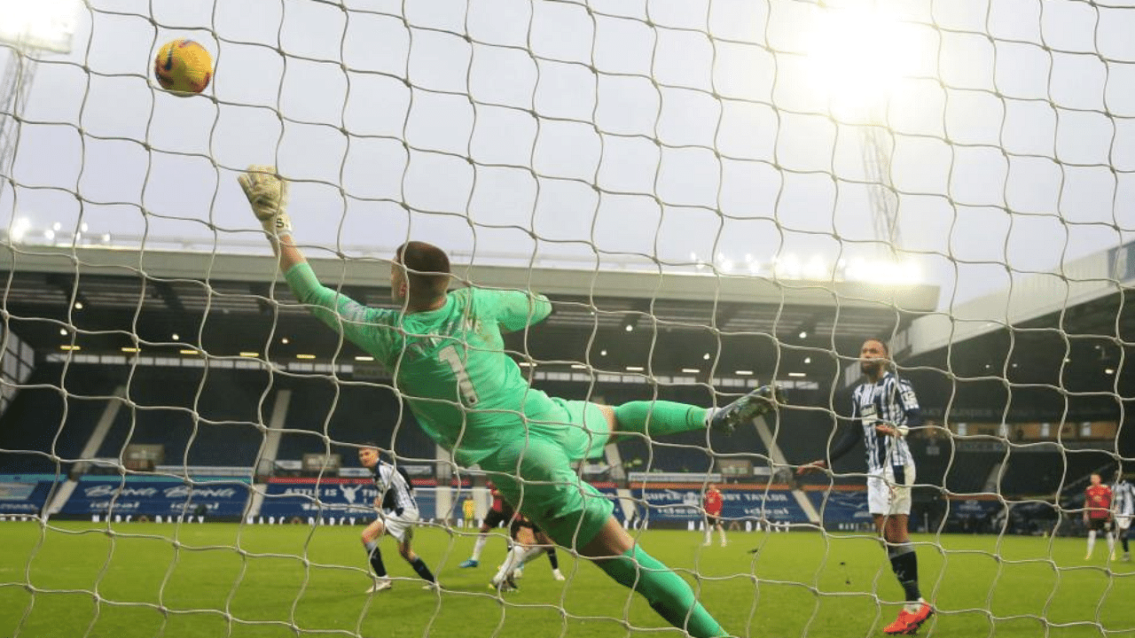 West Bromwich Albion's English goalkeeper Sam Johnston dives to make a save from a header from Manchester United's English defender Harry Maguire during the English Premier League football match between West Bromwich Albion and Manchester United at The Hawthorns stadium in West Bromwich, central England, on February 14, 2021. Credit: AFP Photo
