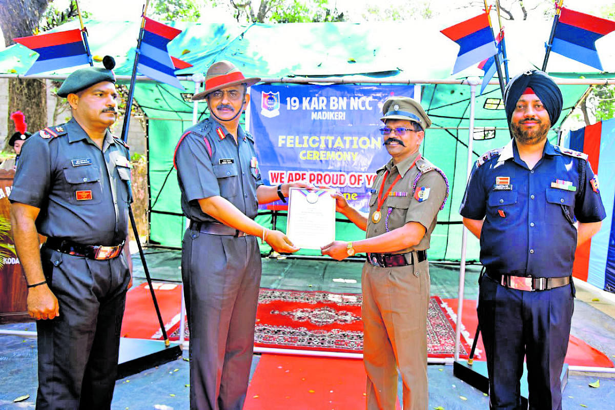 Major Dr B Raghav, NCC officer and head of the history department at Field Marshal K M Cariappa College, being handed the Chief Minister’s medal, by NCC 19th Karnataka Battalion Commanding Officer Col Chethan Dhiman. 