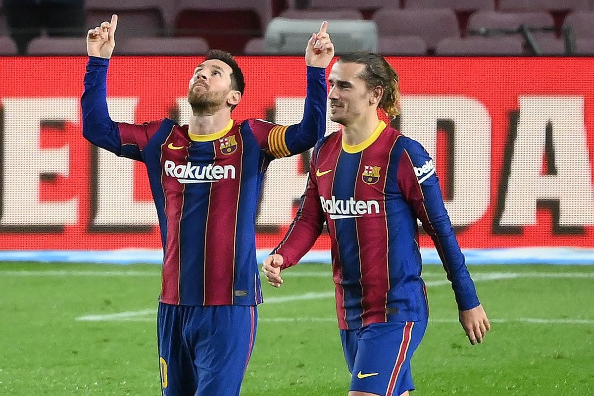 Lionel Messi (L) celebrates with Barcelona's French midfielder Antoine Griezmann after scoring a goal during the Spanish league football match between FC Barcelona and Deportivo Alaves at the Camp Nou stadium in Barcelona. Credit: AFP photo. 