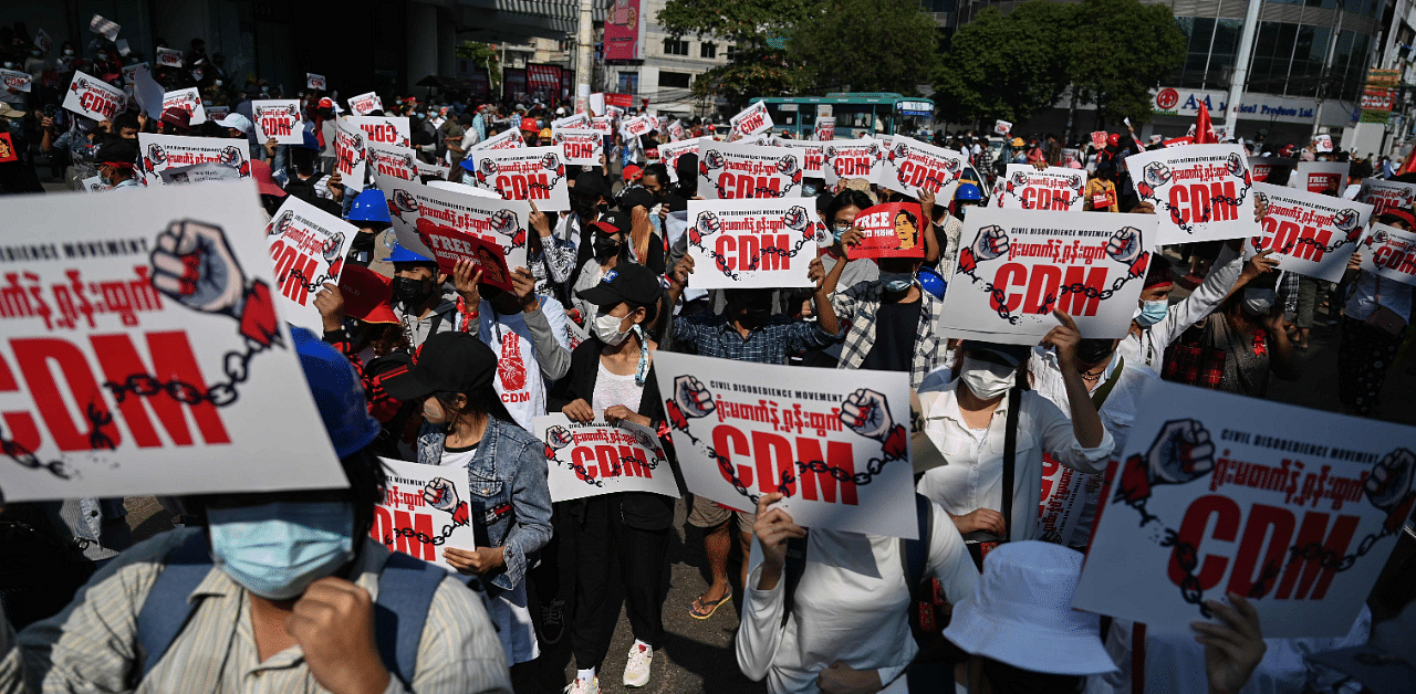 Protesters hold up signs supporting the Civil Disobedience Movement (CDM) at a demonstration against the military coup in Yangon. Credit: AFP Photo