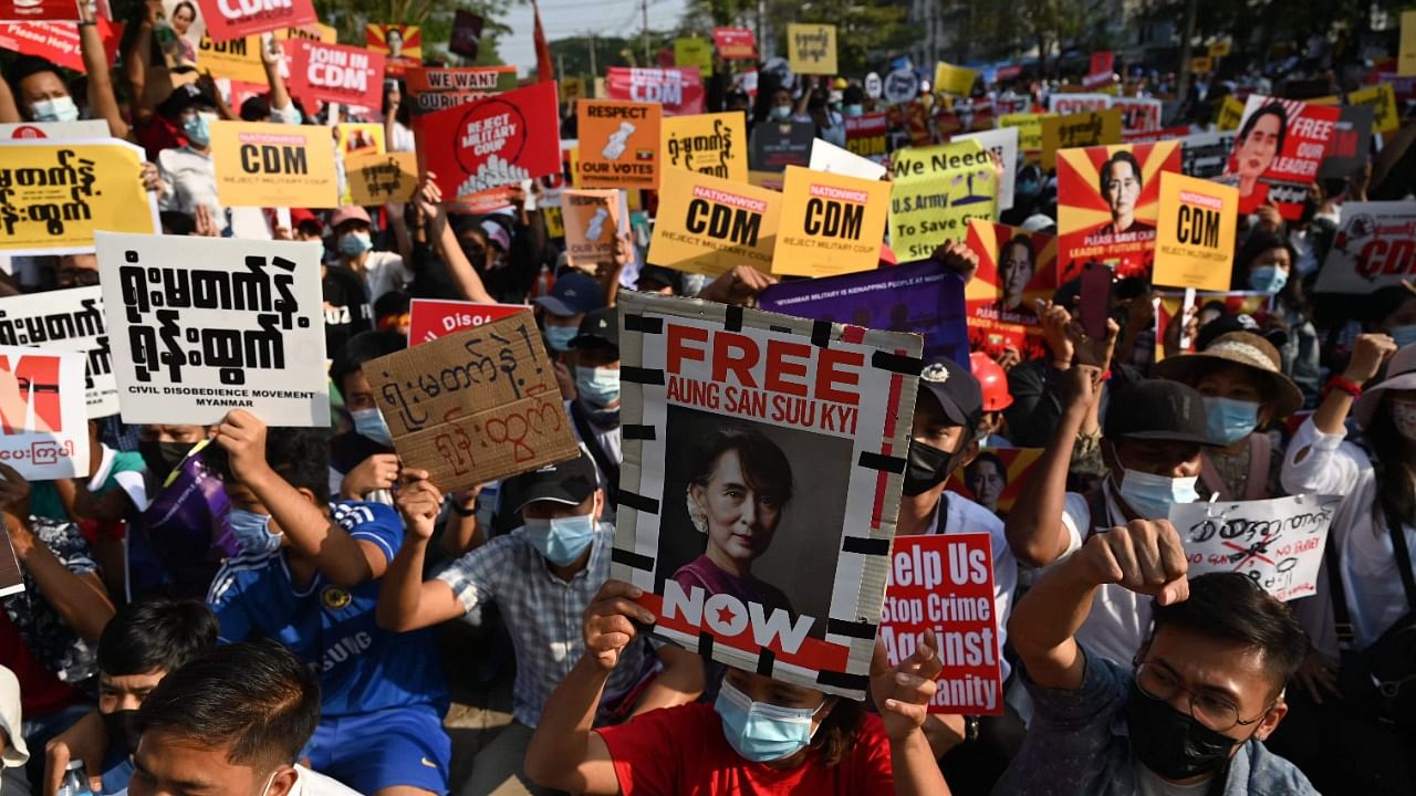 Protesters hold up signs during a demonstration outside the Myanmar Central Bank against the military coup in Yangon on February 16, 2021. Credit: AFP Photo