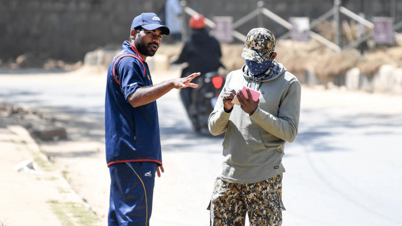 BBMP marshal fining man for not wearing masks off Dickenson Road in Bengaluru. Credit: DH Photo