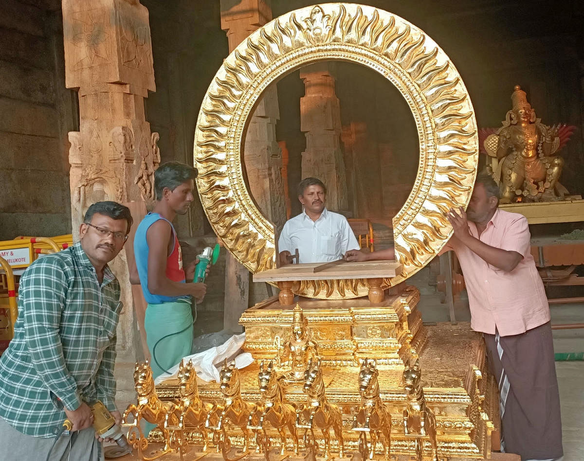 Sculptors from Tamil Nadu give final touches to the gold plated ‘Suryamandala vahana’ to be taken out on a procession, on Ratha Sapthami Day, at Melkote, Mandya district. DH PHOTO