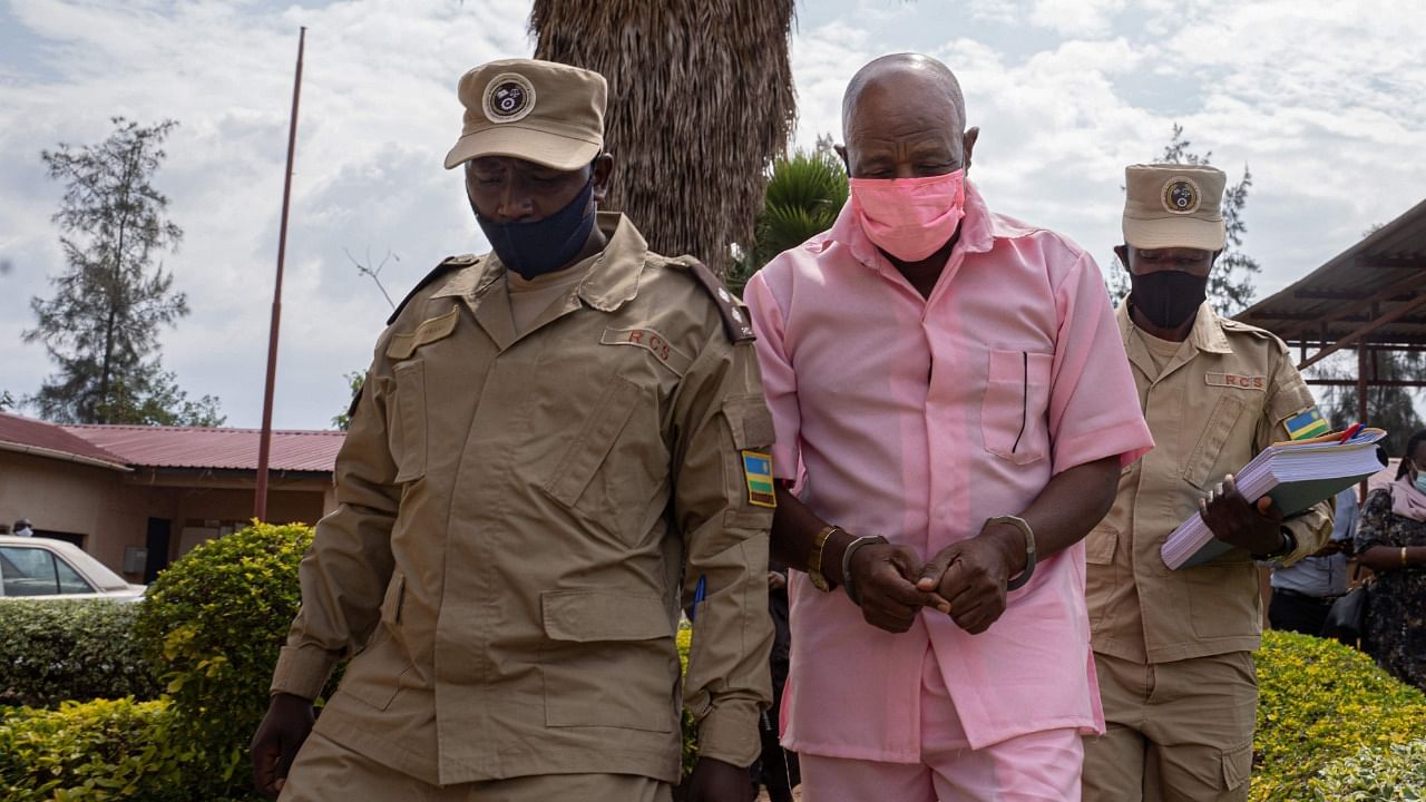 "Hotel Rwanda" hero Paul Rusesabagina (C) in the pink inmate's uniform arriving at Nyarugenge Court of Justice in Kigali, Rwanda, on October 2, 2020, surrounded by guards of Rwanda Correctional Service (RCS). Credit: AFP Photo