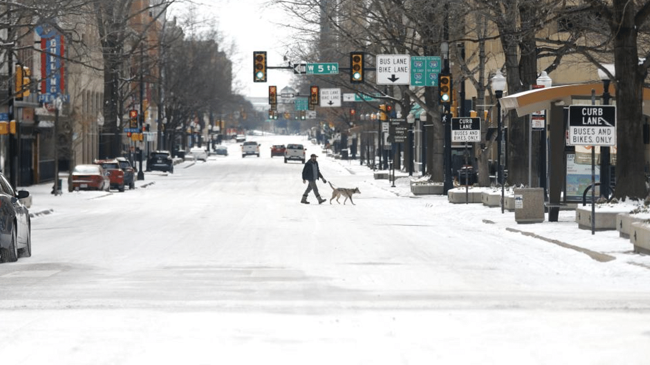  A man walks his dog downtown after a snow storm on February 16, 2021 in Fort Worth, Texas. Credit: AFP Photo
