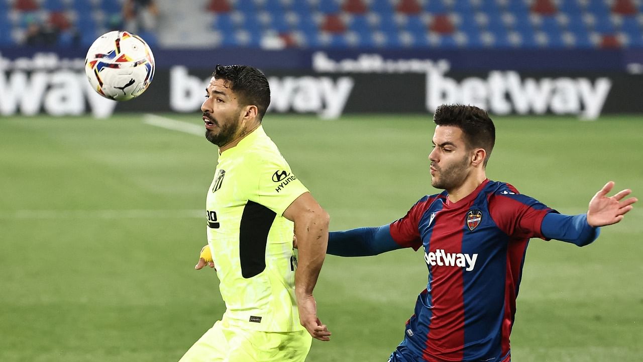 Atletico Madrid's Luis Suarez (L) challenges Levante's Spanish defender Rober Pier during La Liga. Credit: AFP Photo