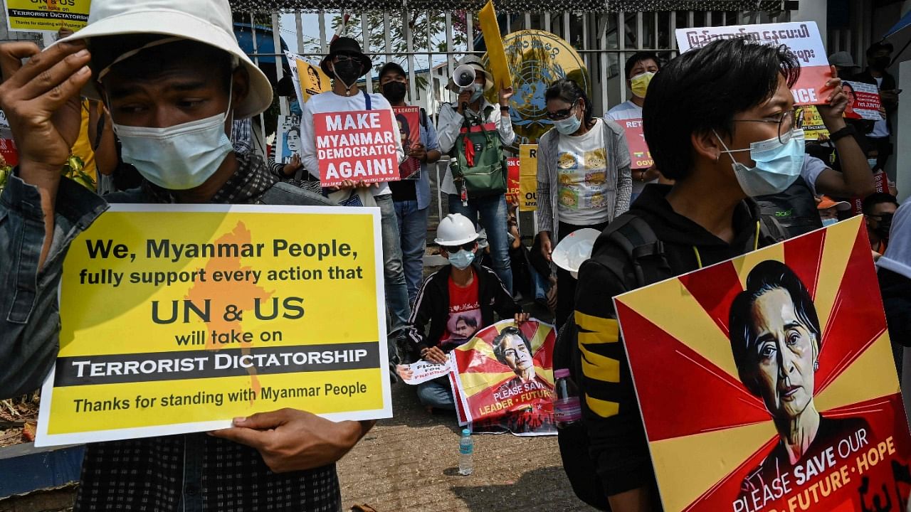 Protesters hold up signs during a demonstration against the military coup outside the UN office in Yangon on February 18, 2021. Credit: AFP Photo