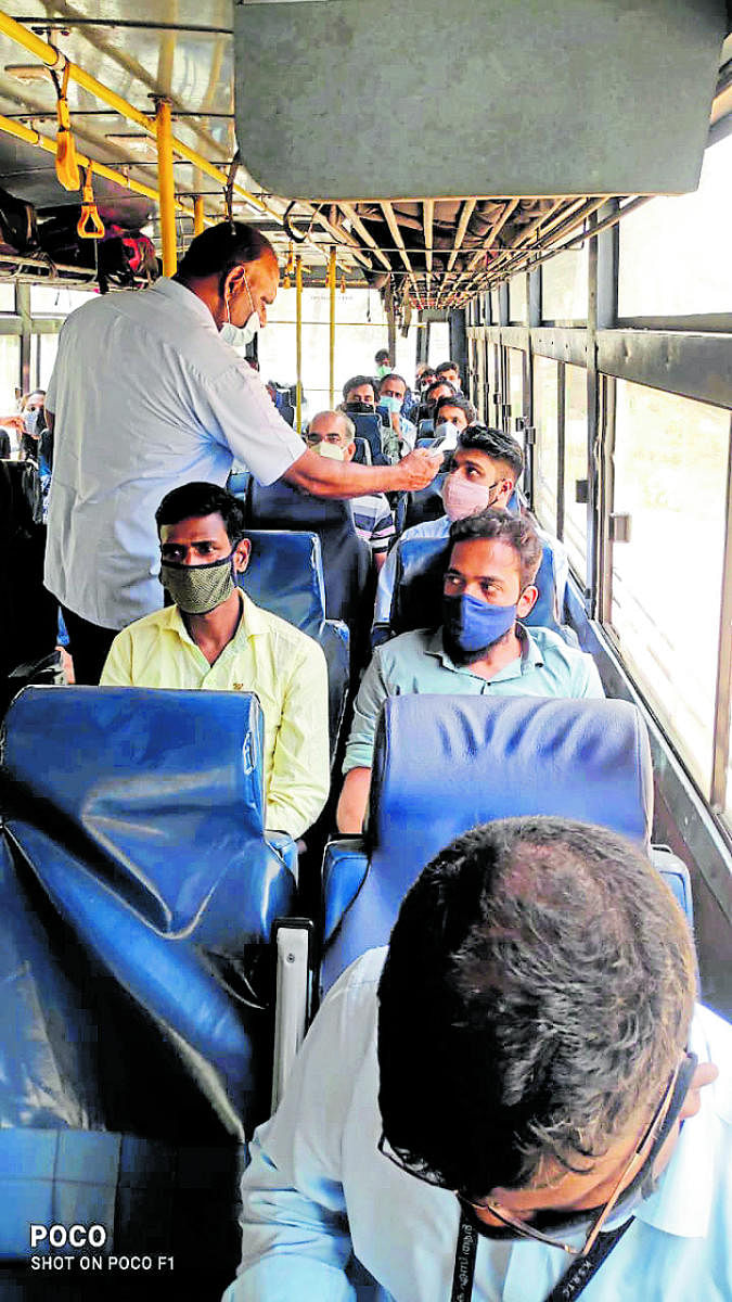 Health department personnel conduct thermal screening of passengers coming from Kerala, at a checkpost in Gundlupet, Chamarajanagar district, on Thursday.
