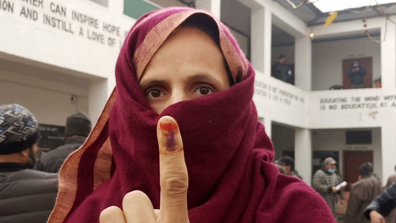 A woman shows her ink-marked finger after casting her vote during the third phase of DDC elections, at a polling station in Ganderbal area of Central Kashmir, Friday, December 4, 2020. Credit: PTI Photo