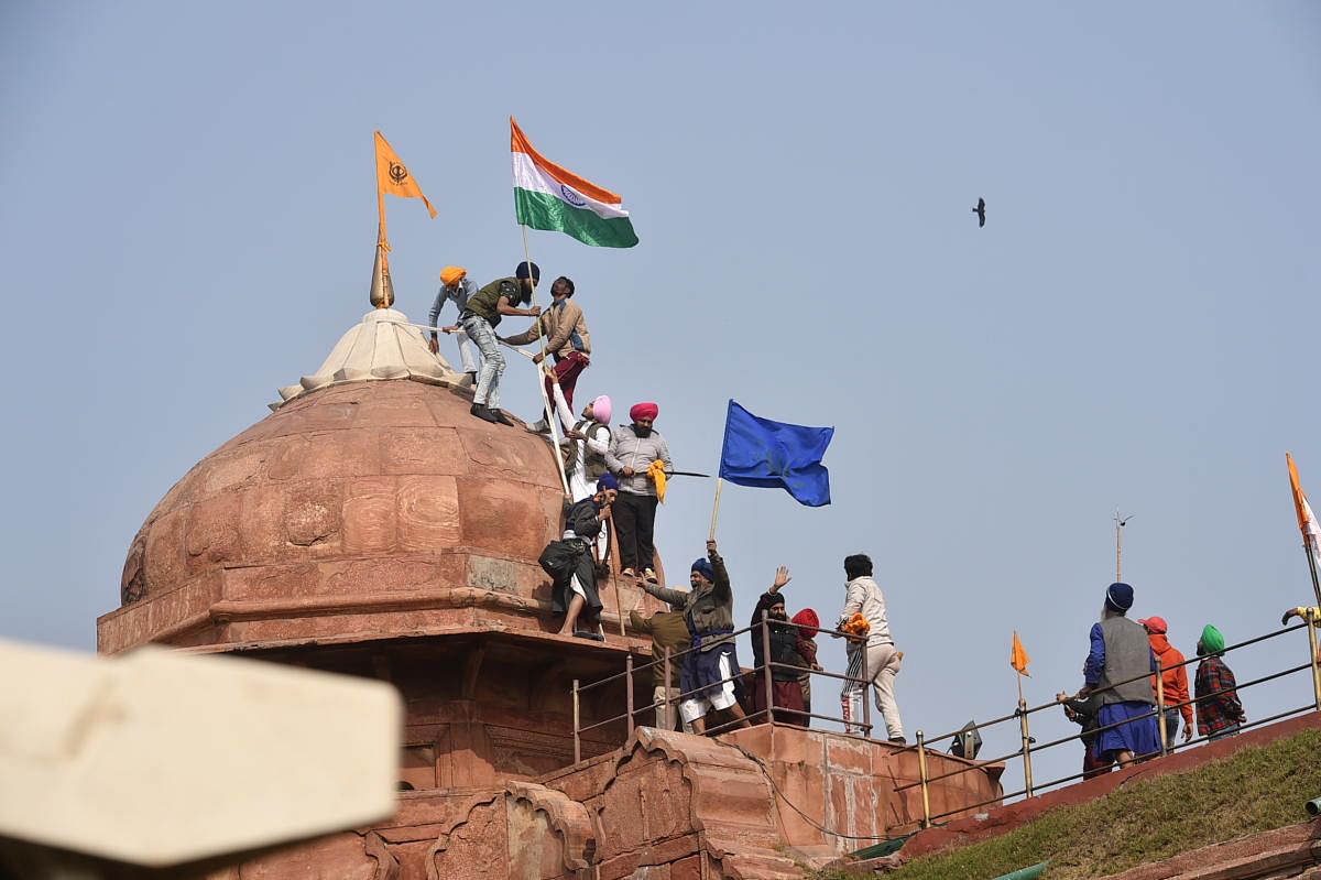 Farmers post flags on a dome of Red Fort after their tractor parade on Republic Day, in New Delhi, Tuesday, Jan. 26, 2021. Credit: PTI Photo