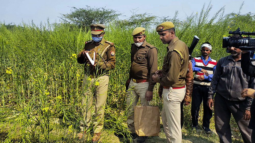  Police personnel investigate at the site where bodies of two minor Dalit girls were found in a field and another in critical condition. Credit: PTI Photo
