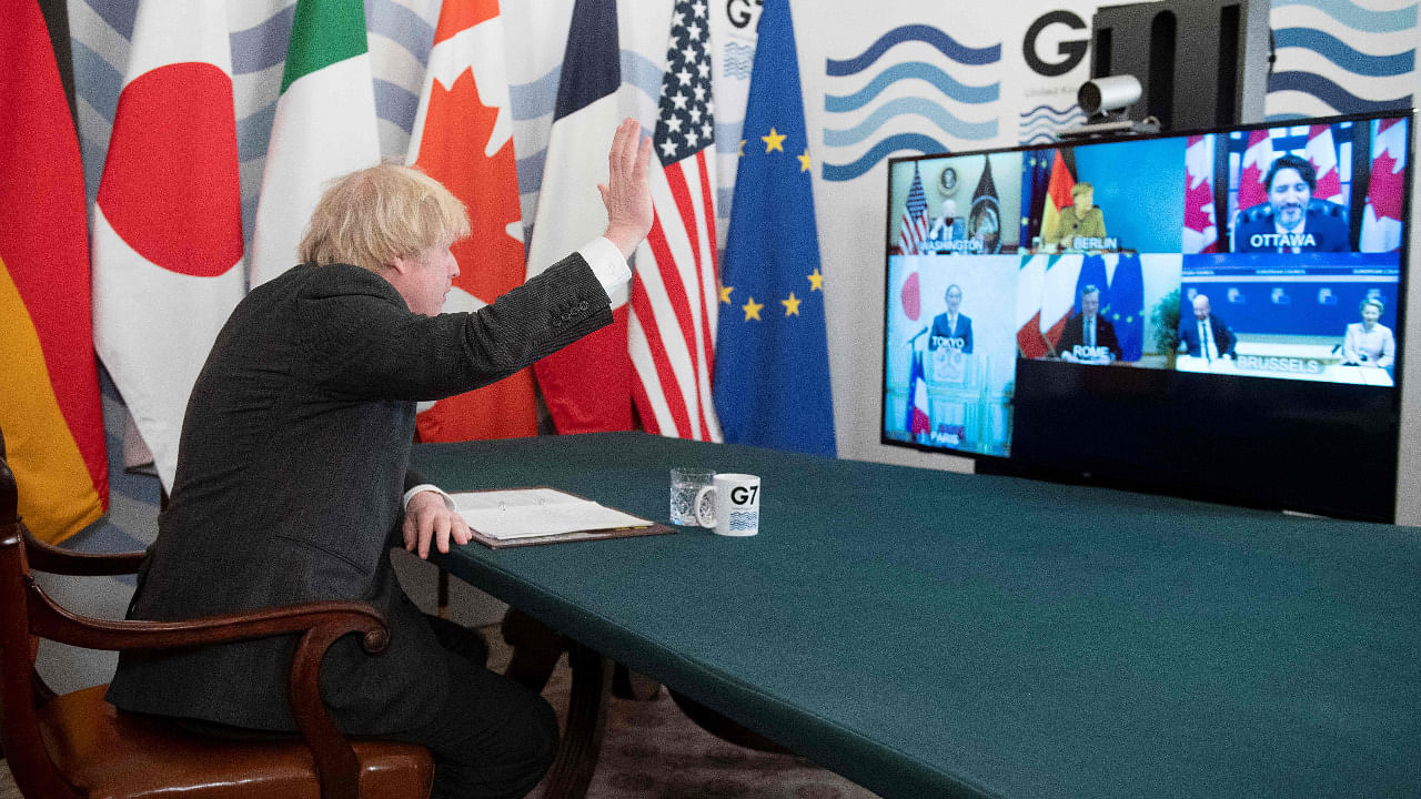Prime Minister Boris Johnson waves as he hosts a virtual meeting of G7 leaders in the Cabinet Room at Downing Street in London. Credit: AFP Photo