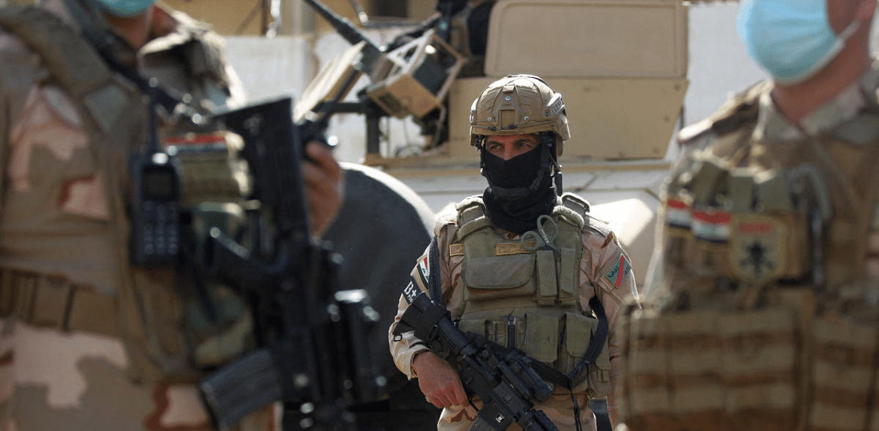 A member of the Iraqi force stands at attention during a search of the area in Tarmiyah, 35 kilometres (20 miles) north of Baghdad on February 20, 2021, following clashes with Islamic State group fighters. Credit: AFP Photo