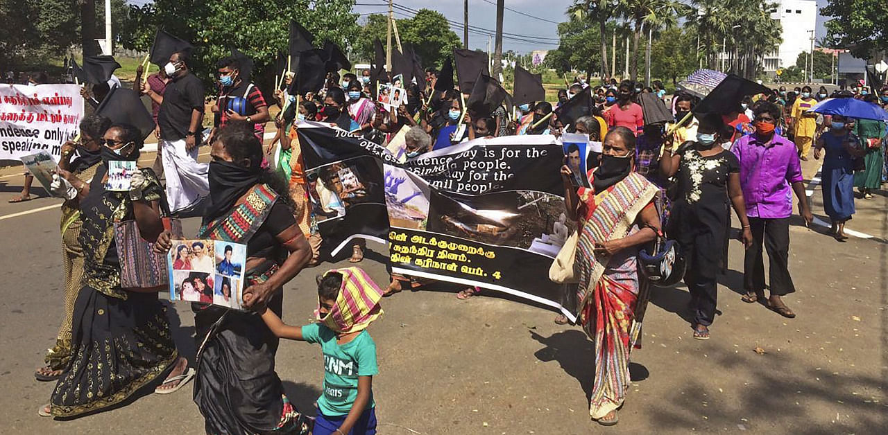 Demonstrators carry black flags and pictures of missing Tamils during a protest march in Sri Lanka’s northern town of Kilinochchi. Credit: AFP Photo