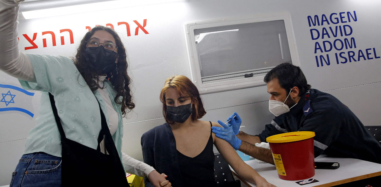 A health worker administers the COVID-19 vaccine to an Israeli at mobile clinic parked near a bar in the coastal city of Tel Aviv. Credit: AFP Photo