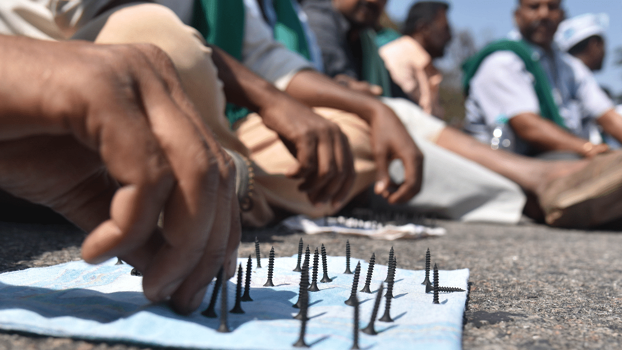 Farmers arranging nails during their protest on Airport road near Sadanahalli gate during the nationwide Chakka Jam. Credit: PTI Photo
