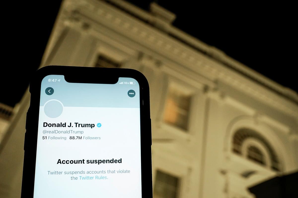 A photo-illustration shows the suspended Twitter account of former US President Donald Trump on a smartphone, with the White House residence in the background. Reuters