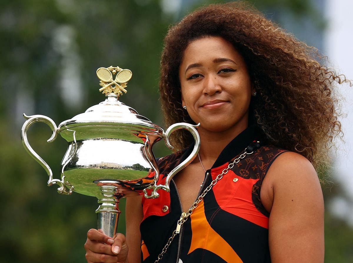Naomi Osaka of Japan poses with the 2021 Australian Open winner's trophy at the Government House in Melbourne. Credit: AFP photo. 