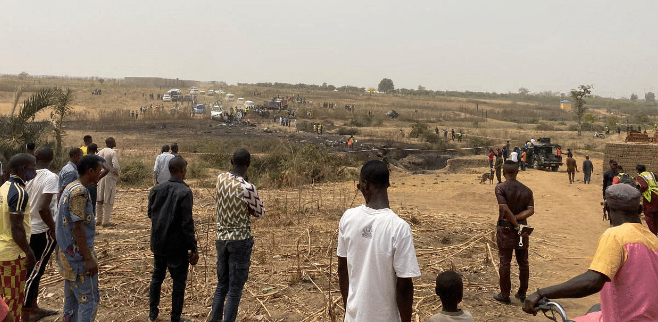 People watch as rescuers inspect the debris from a Nigerian air force plane, which crashed while approaching the Abuja airport runway according to the aviation minister, in Abuja, Nigeria. Credit: Reuters photo.